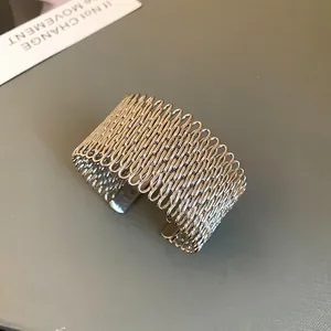 Close-up of a wide silver geometric cuff bracelet with unique industrial link design