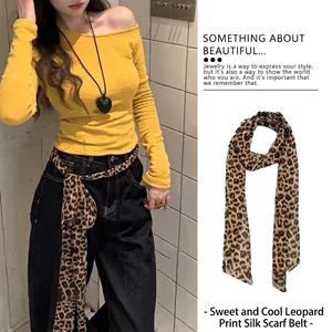 Vista dettagliata della sciarpa in seta leopardata usata come cintura alla moda