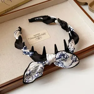 Detail of vintage fabric wrapped headband with floral bow and teeth for hair volume