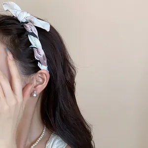 Detail shot of a Korean fabric silk scarf wrapped bow headband on an Asian model