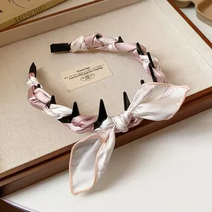 Detail view of pink and white silk scarf wrapped headband with bow