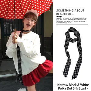 Vista dettagliata di un foulard sottile retrò a pois neri e bianchi in stile choker
