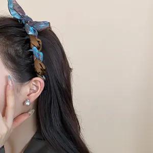 Side view of a vintage twisted silk scarf headband on a model with long dark hair