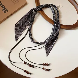 Cintura a sciarpa intrecciata boho vintage con motivo paisley e dettagli in legno.