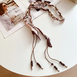 Vista dettagliata della cintura intrecciata paisley boho con eleganti ciondoli in legno