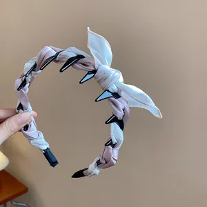 Detailed macro view of a pink and white fabric wrapped headband with a bow and teeth