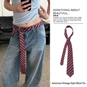 Dettaglio di una cintura a cravatta in seta a righe vintage americana con jeans