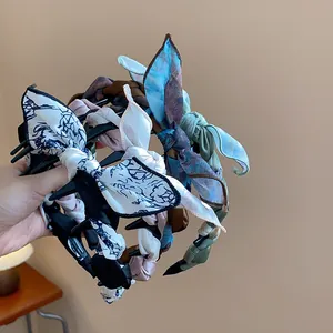 Detailed close-up showing various vintage fabric wrapped bow headbands with floral prints