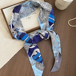 Dettaglio ravvicinato della cintura a sciarpa in seta con motivo paisley blu e bianco