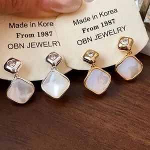 Detail view of 18k gold plated heart zircon rhombic clip-on earrings with shell finish