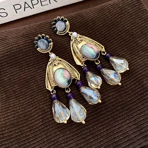 Detailed macro view of vintage palace style gold-tone earrings with crystal drops and pearls