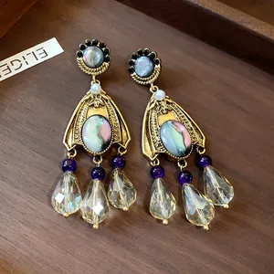 Detailed macro shot of vintage court-style earrings with pearl and crystal pendants.