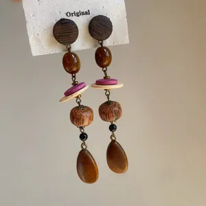 Vue détaillée de boucles d'oreilles pendantes vintage avec des éléments en bois.