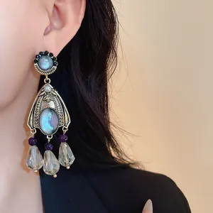 Close-up of vintage palace-style chandelier earrings with iridescent stones on a model.