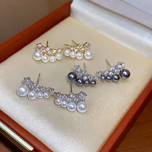 Elegant 18k gold plated silver stud earrings with pearls and zircon in curved design.