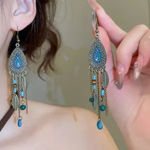 Gros plan de boucles d'oreilles ethniques rétro bohème avec perles bleues