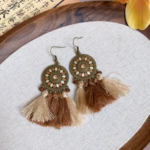 Vue détaillée de boucles d'oreilles ethniques rétro avec pompons et design mandala complexe