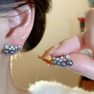 Detail shot of elegant black pearl and zircon earrings with 18k gold plating finish