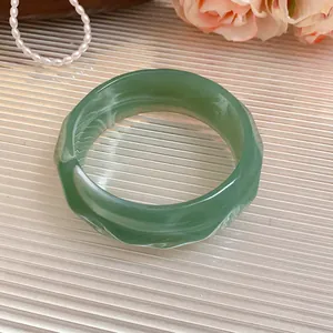 Close-up detail view of a green marbled acrylic faceted bangle with striped texture