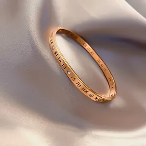 Detailansicht eines roségoldenen Armreifs mit römischen Ziffern und Zirkonia-Steinen