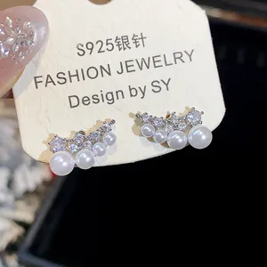 Macro view of elegant 18K gold plated S925 silver stud earrings with pearls and zircons