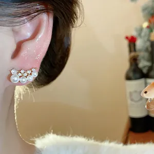 Detailed view of elegant zircon and pearl ear studs with 18K gold plating worn on ear