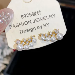 Detailed macro view of 18k gold plated S925 silver needle zircon pearl stud earrings