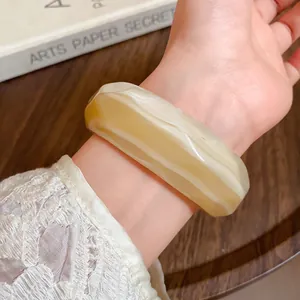 Close-up detail of amber marbled acrylic bangle with a faceted geometric surface