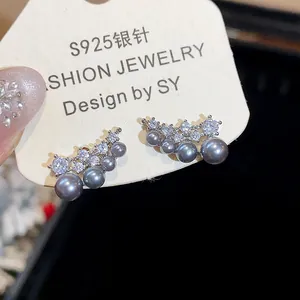 Detail of S925 silver stud earrings featuring grey pearls and sparkling zircons