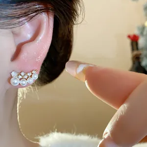 Detailed macro view of elegant 18k gold plated earrings with pearls and shiny zircons