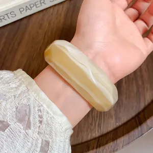Macro view of marbled acrylic bangle with faceted edges on a wrist for daily fashion