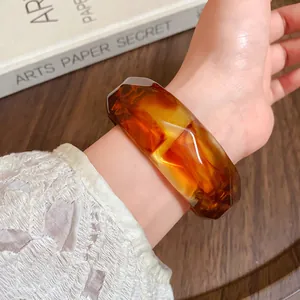 Close-up of amber acrylic ink-stained faceted bangle showing texture and stripes