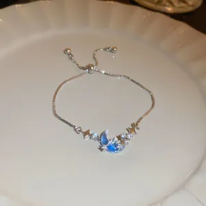 Elegant silver-toned adjustable star and moon bracelet with blue zircon accents