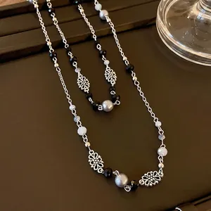 Elegante lange Vintage-Halskette mit Blumenanhängern und grauen Kunstperlen für Damen.