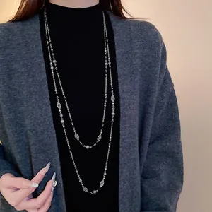 Lange Vintage-Pulloverkette mit silbernen Blumen und grauen Perlen an einem Model