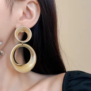 Close-up of golden textured double hoop earrings with a stylish hollow design