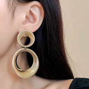 Detailed view of elegant gold textured double hoop earrings worn by a female model