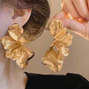 Statement gold metal flower stud earrings with textured petal design for women