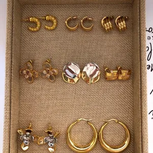 Varietà di orecchini eleganti in oro e argento stile coreano in un vassoio intrecciato