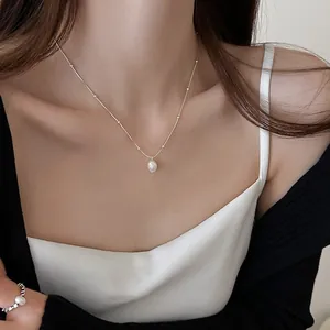 Elegant stainless steel necklace with a dainty freshwater pearl pendant worn by a model