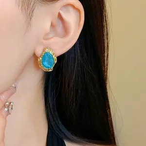 Detaillierte Nahaufnahme eines blauen Vintage-Ohrsteckers mit Sternensand auf einem Ohr