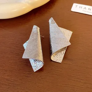 Detail shot of silver irregular geometric metal earrings with architectural striped texture