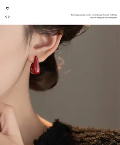 Close-up detail of an elegant red geometric drop oil earring on a female model