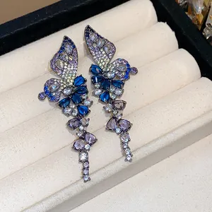 Detailed view of vintage butterfly wing earrings with vibrant blue and purple crystals