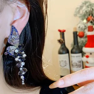 Close-up of vintage zircon butterfly wing earring worn on ear with silver needle.