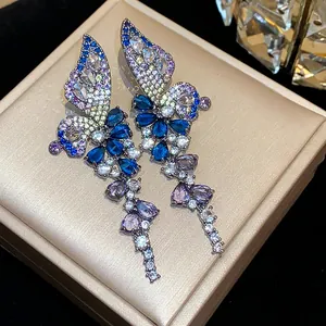 Detailed close-up of vintage butterfly wing earrings featuring multicolored zircon stones