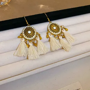 Detailansicht von Böhmischen Quastenohrringen mit Sonnenmotiv und cremefarbener Seide.