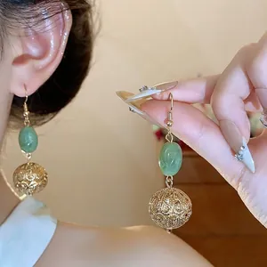 Vintage Chinese style gold earrings with green resin beads and hollow round pendants