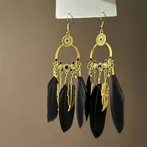 Detailansicht der Vintage-Böhmen-Ohrringe in Gold mit eleganten schwarzen Federn und Perlen.