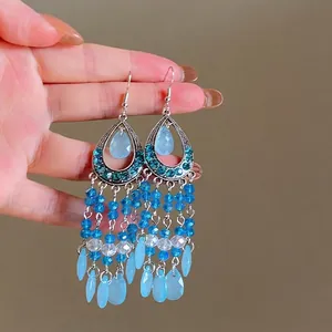 Nahaufnahme von böhmischen blauen Quastenohrringen mit facettierten Kristallperlen.